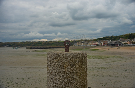 背景为沙滩沿海城镇的锚固船用混凝土砌块