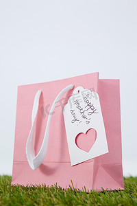 粉色背景贺卡摄影照片_纸袋上的快乐母亲节贺卡