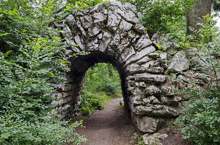 自然老西公园各种植物的旧废弃假山石拱灌木景观