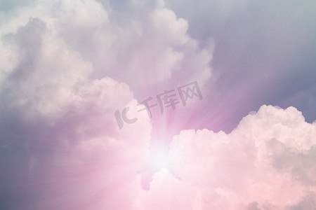 蓝天、背景中的太阳和美丽的粉红色白云