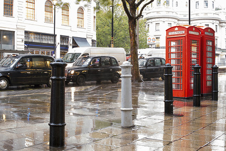 伦敦的红色电话亭和老式出租车。下雨天。