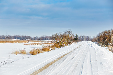 阳光明媚的日子里，沿着湖边的雪路