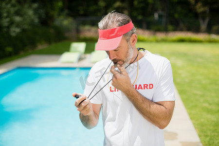 游泳知识摄影照片_游泳教练看着池畔附近的秒表