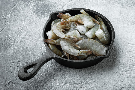 健康的有机虎虾，铸铁煎锅，灰色石头背景，有文字复制空间