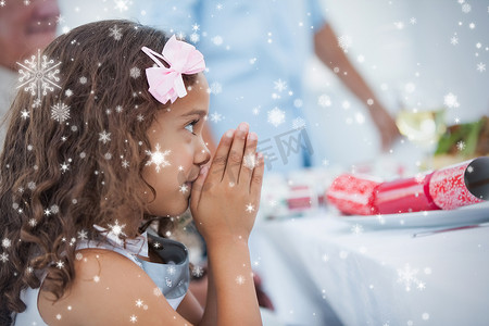 坐在桌边祈祷的小女孩的合成图像