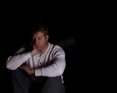 不成熟摄影照片_坐在黑暗中的成熟男人表现出抑郁