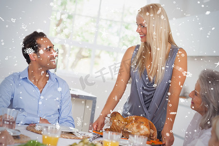 幸福的妻子把火鸡带到餐桌上的合成图像