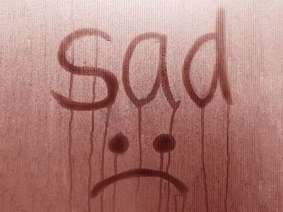 由 sad 和 Emoji 写在粉红色雾状玻璃上。