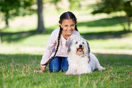 微笑的女孩和她的宠物狗玩耍的肖像