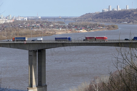 大型卡车驶过城市河流上的大桥。