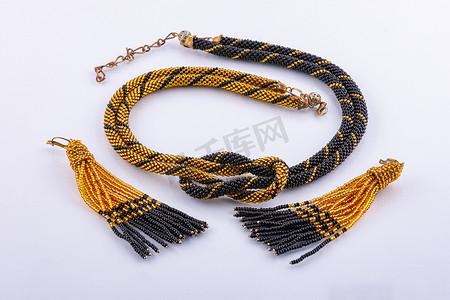 手工制作的项链和耳环，由黑色和金色的小珠子组成