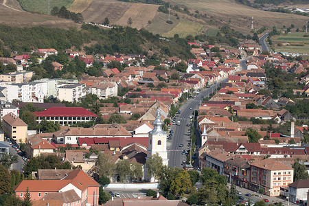 农村山丘摄影照片_2021 年罗马尼亚 Rupea 镇中心的鸟瞰图，包括山丘、建筑物、街道、植被和周围环境