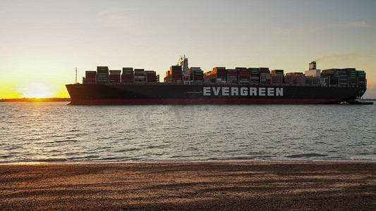 港口拖车摄影照片_萨福克郡费利克斯托港，黄昏时太阳落在船头上的 Ever Gentle 号船