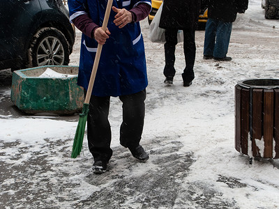 雪街道摄影照片_暴风雪过后，男子在人行道上除雪。