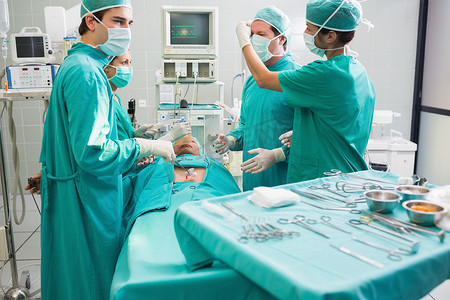 失去摄影照片_外科医生在手术室为失去知觉的病人做手术
