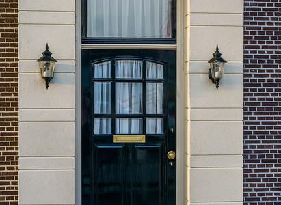 一栋豪华住宅的木质前门，有两个未点亮的灯笼，现代荷兰建筑背景