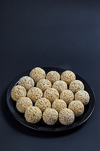 黑色背景的黑色盘子中的苋菜 ladoo 或 Rajgira laddu 或 Cholai ke laddu。