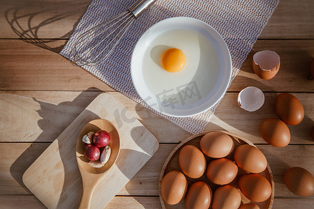 破了的鸡蛋摄影照片_鸡蛋放在木托盘上，鸡蛋破了。