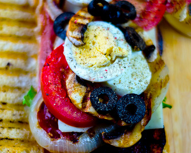脆骨烤肠摄影照片_烤三明治，包括各种冷肉、奶酪、蘑菇、番茄和鸡蛋，美味健康的小吃