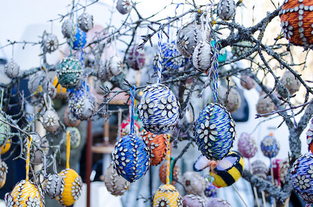 手工制作的复活节彩蛋挂在树枝上的春季集市