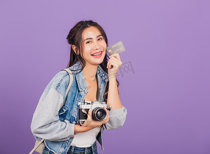 银行和摄影照片_拿着借记信用卡银行和复古古董相机的女人兴奋地微笑着摄影师