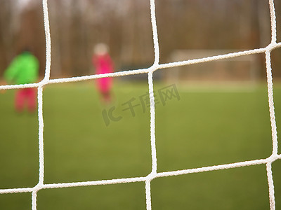 网闸摄影照片_足球运动员用球网和体育场反对球门。