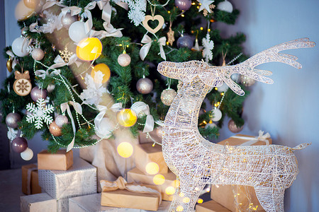 喜庆的装饰鹿站在房间里的圣诞树附近