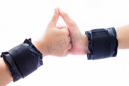 人类的一只手是一只男性，另一只女性的手被白色隔离，戴着黑色腕带或手腕重量被隔离在白色上。做各种手势以显示团结和力量。