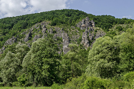 山形状山峰摄影照片_大而形状良好的岩石类似于人类、野兽和其他奇异形式的山峰 Garvanets 或乌鸦是 Lozenska 山最有趣的自然地标