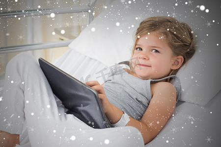 生病女孩在医院病床上使用数字平板电脑的合成图像