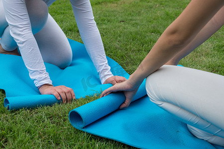 2 位女士在瑜伽课后保留瑜伽垫。
