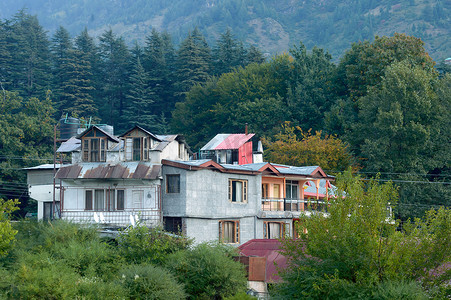 中老年群体摄影照片_全景老旅馆小屋复古风格的建筑，在春天的喜马拉雅山谷中，周围环绕着松树林。