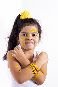 快乐的小女孩，脸上涂着彩绘来庆祝黄色的日子
