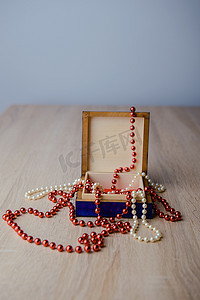 木制背景上的礼品盒和红珠项链