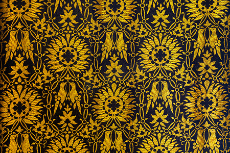 迎春花鸟摄影照片_金色和黑色挂毯或织物图案的特写，带有花鸟背景背景
