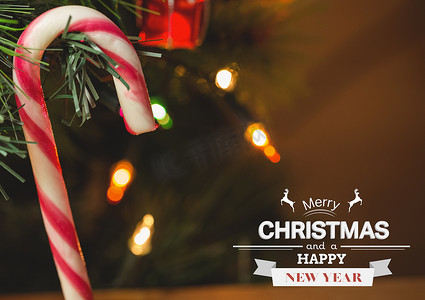 圣诞快乐和糖果手杖挂在圣诞树上对着散景灯的合成图像