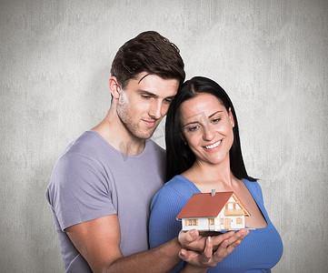 拿着模型房子的年轻夫妇的综合图象