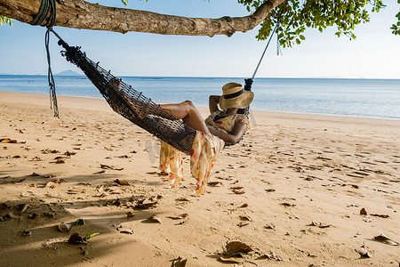 展架暑假招生摄影照片_快乐的旅行者在吊床上放松，在秋千上放松，看着美丽的自然景观，安达曼海，甲米，旅游海滩泰国，亚洲，暑假旅行