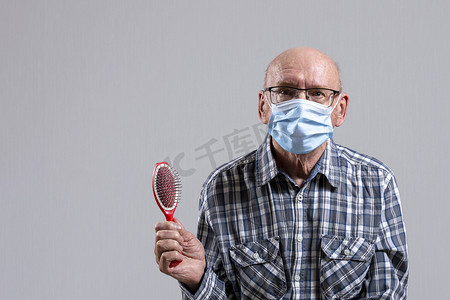 秃头老头戴着眼镜，戴着医用面具，手里拿着梳子。
