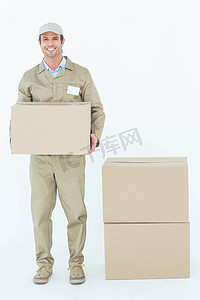 愉快的背景摄影照片_拿着纸板箱的愉快的送货员