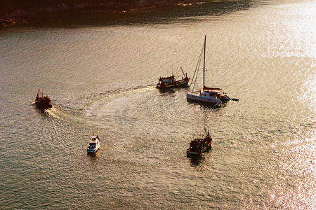 海上帆船运动摄影照片_夕阳下海上的游艇