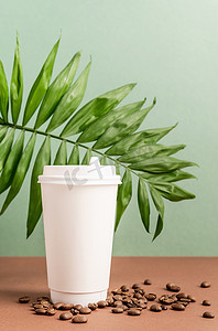 环保三叶草摄影照片_带热带叶和咖啡豆的环保一次性白纸杯，模拟设计