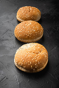 黑石背景中带芝麻的新鲜自制汉堡包