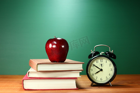 书籍课本摄影照片_课本、苹果和学校桌上的时钟