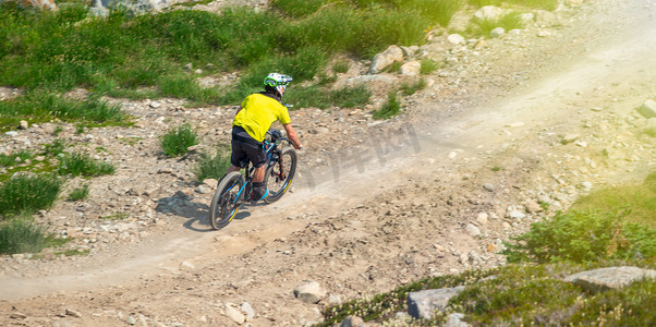 在山间摄影照片_夏季在山间小径上骑自行车