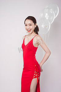 身穿红裙、带淡色气球的亚洲美女