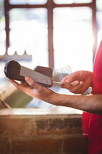服务员将顾客的信用卡插入刷卡机