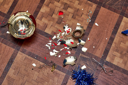 碎片彩色玻璃摄影照片_破碎的圣诞树玩具和地板上的彩色玻璃碎片