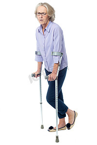 拄着拐杖走路疼痛的老妇人