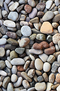 五颜六色的灯关摄影照片_海边沙滩上美丽的五颜六色的石头。